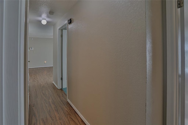 hall with a textured ceiling and dark hardwood / wood-style floors