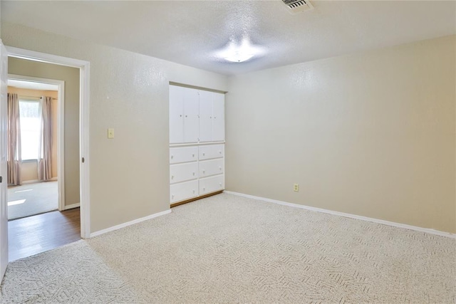 unfurnished bedroom featuring carpet and a textured ceiling