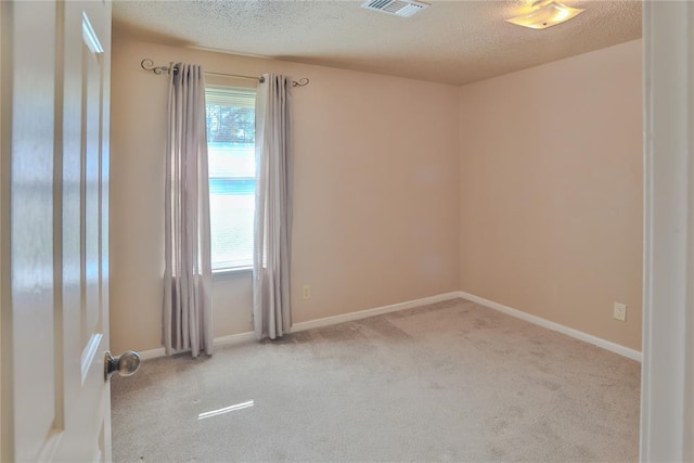 carpeted spare room featuring a textured ceiling