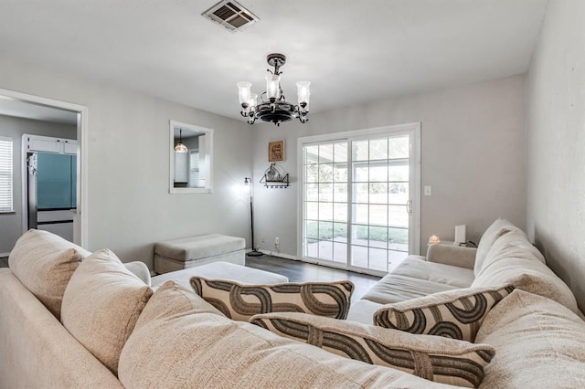 living room with hardwood / wood-style floors and a notable chandelier