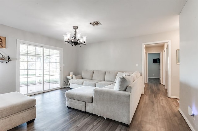 living room with dark hardwood / wood-style floors and an inviting chandelier