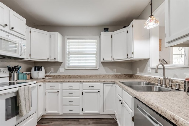 kitchen with white cabinetry, sink, dark hardwood / wood-style floors, decorative light fixtures, and white appliances