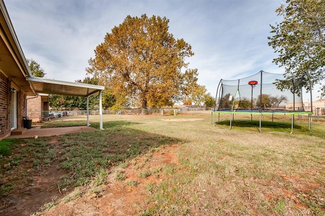 view of yard with a trampoline and a patio area