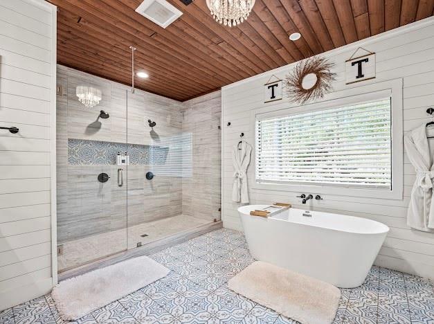 bathroom featuring wood walls, plus walk in shower, wood ceiling, and an inviting chandelier