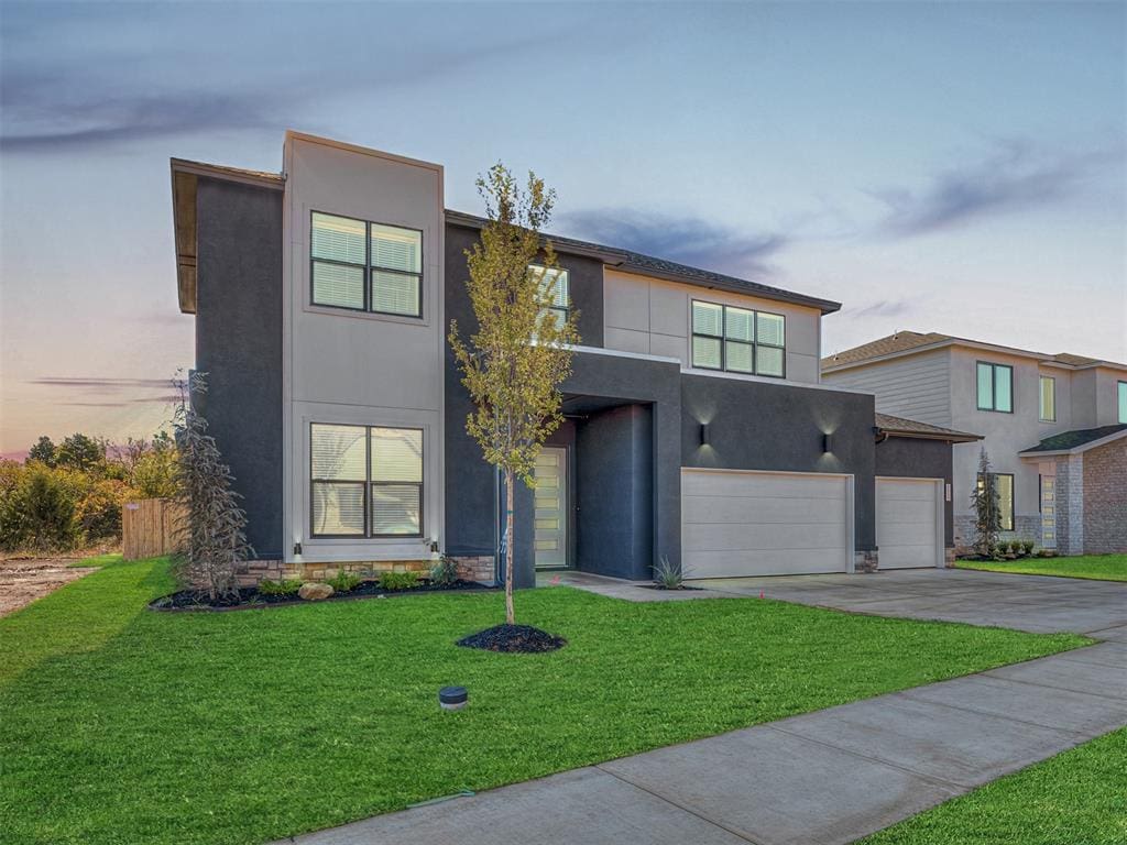 modern home featuring a lawn and a garage