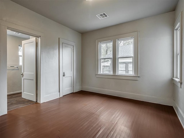 unfurnished bedroom with dark hardwood / wood-style floors and a closet