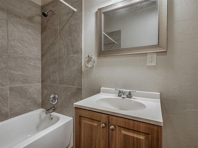 bathroom featuring tiled shower / bath combo and vanity