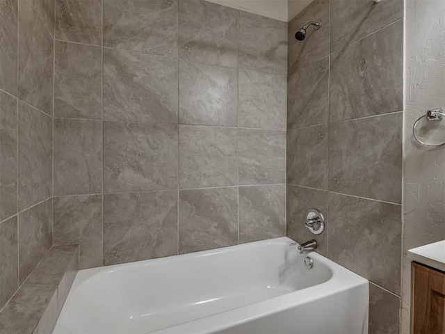 bathroom with tiled shower / bath combo and vanity