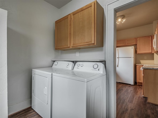 laundry room featuring cabinets, dark hardwood / wood-style floors, and washing machine and dryer