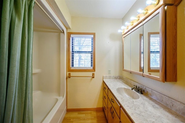 bathroom featuring hardwood / wood-style floors, vanity, and shower / tub combo