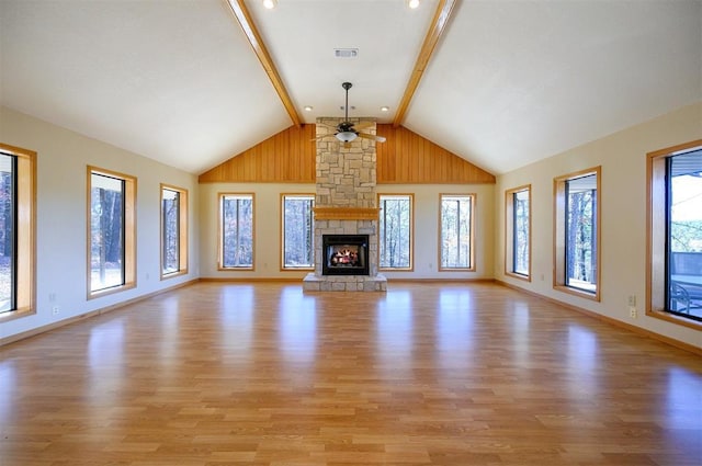 unfurnished living room with a fireplace, ceiling fan, high vaulted ceiling, light hardwood / wood-style flooring, and beamed ceiling