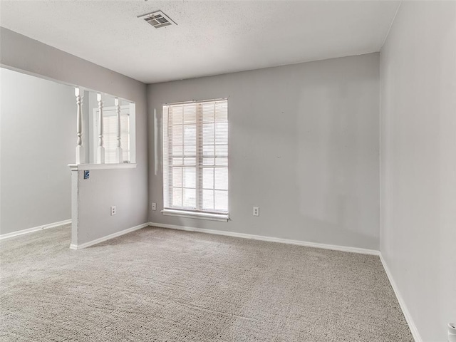 spare room featuring carpet and a textured ceiling