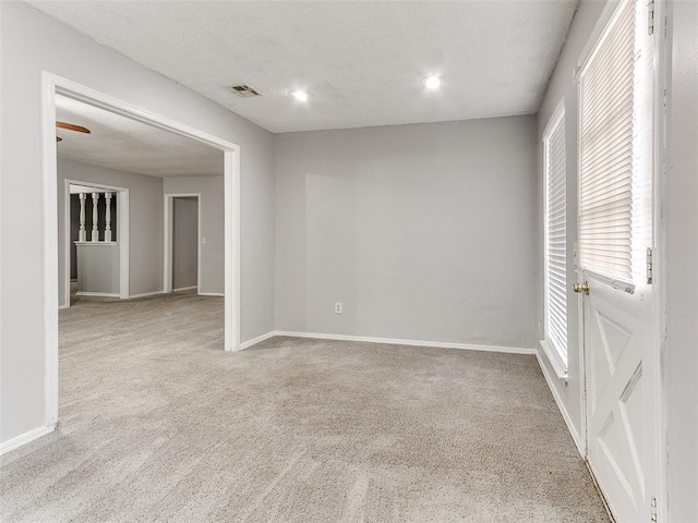 spare room featuring ceiling fan and light colored carpet