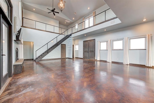 unfurnished living room with high vaulted ceiling and ceiling fan