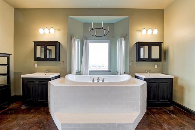 bathroom with tiled bath, vanity, and a notable chandelier