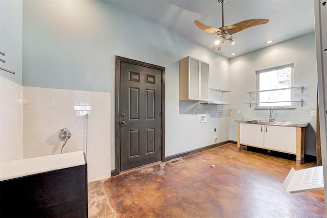 laundry area with ceiling fan, sink, and a high ceiling