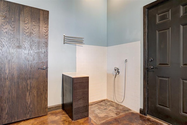 bathroom with a shower and concrete floors