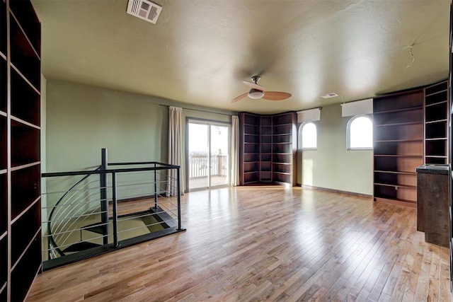 unfurnished room featuring light wood-type flooring, plenty of natural light, and ceiling fan