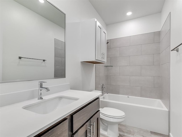 full bathroom featuring toilet, tiled shower / bath, and vanity