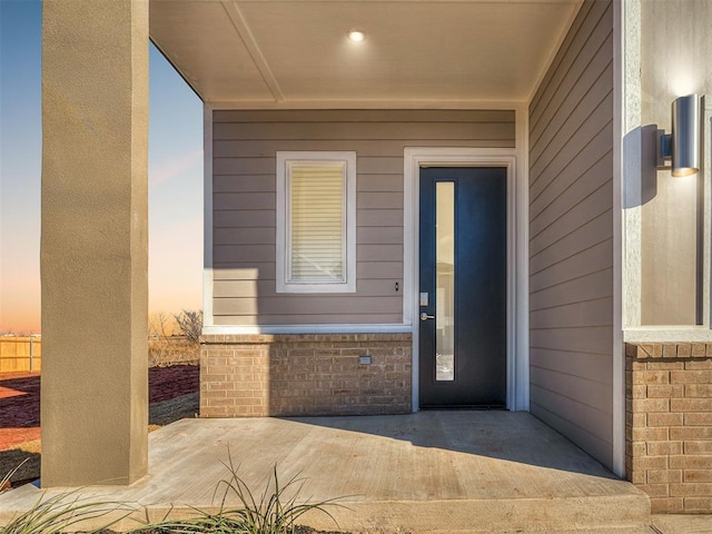 exterior entry at dusk featuring a patio area