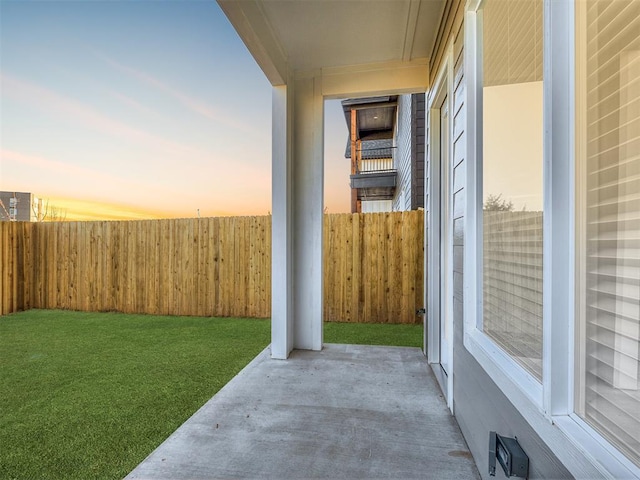 yard at dusk featuring a patio area