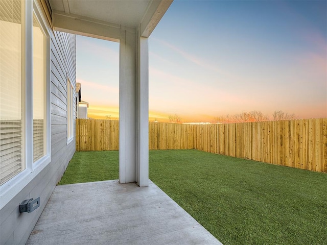 yard at dusk featuring a patio area