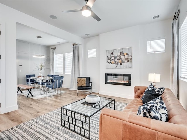 living room featuring ceiling fan and light hardwood / wood-style flooring