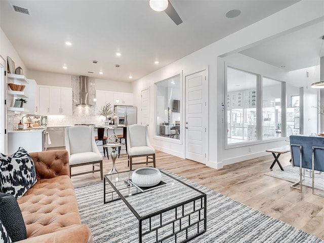 living room featuring light wood-type flooring and ceiling fan