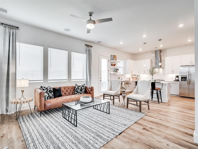 living room with ceiling fan and light hardwood / wood-style floors