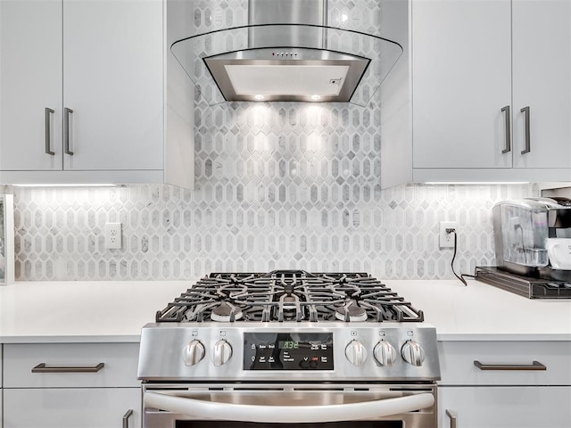 kitchen featuring backsplash, stainless steel range oven, and range hood