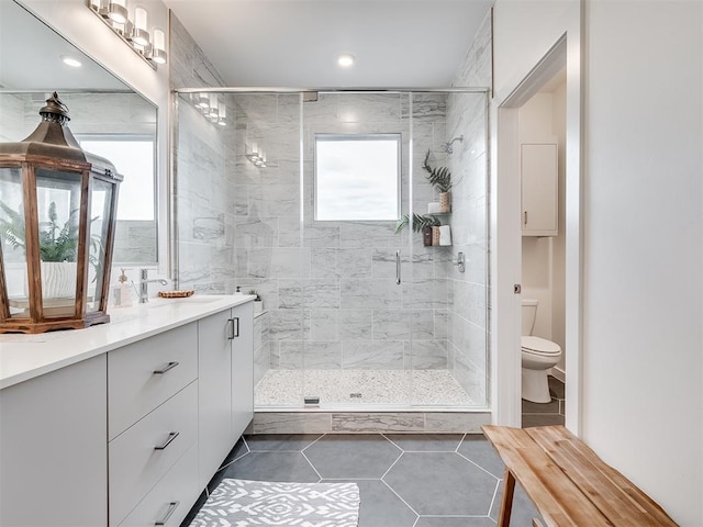 bathroom with toilet, tile patterned floors, a shower with door, and vanity