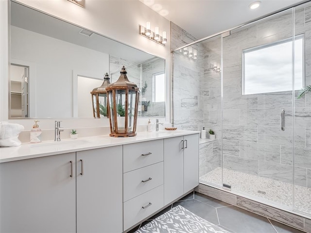 bathroom featuring a shower with door, vanity, and tile patterned flooring