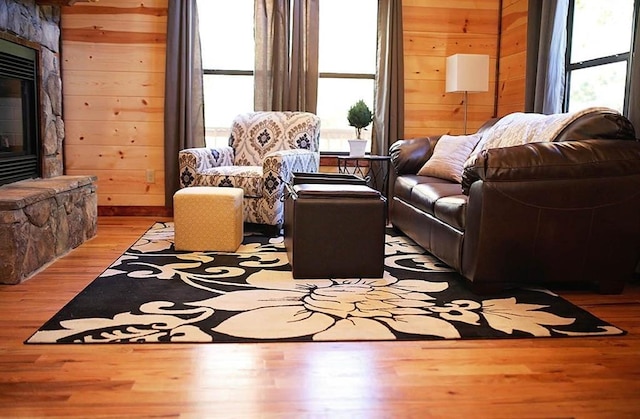 living room featuring wood walls, a fireplace, and hardwood / wood-style flooring