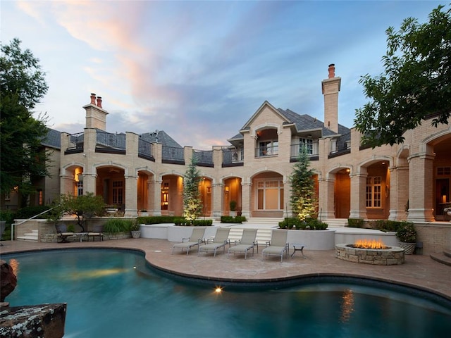 back house at dusk featuring a patio