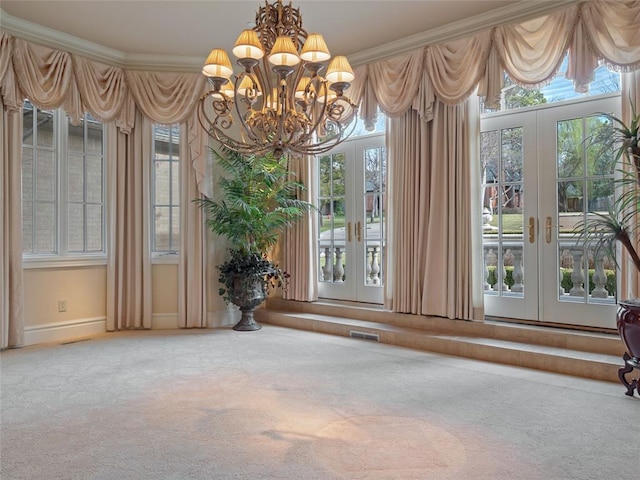 unfurnished dining area featuring plenty of natural light, crown molding, and french doors