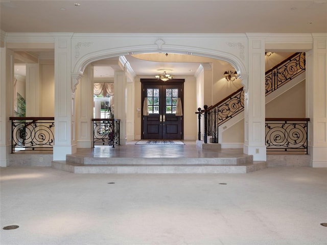 entryway with carpet, ornamental molding, and french doors