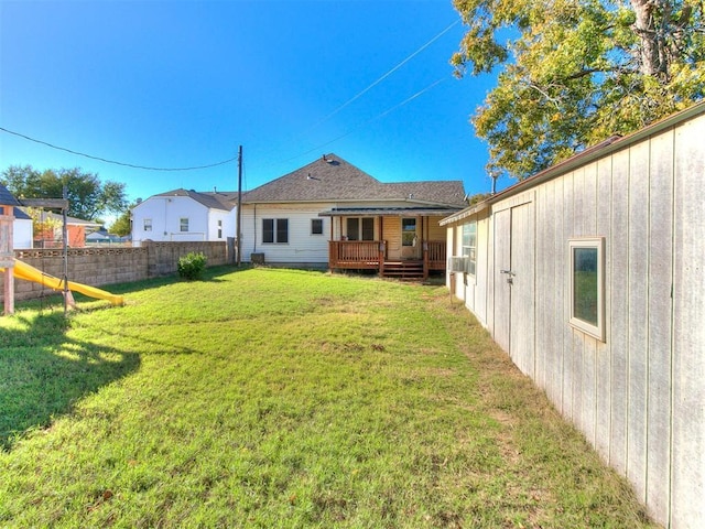 back of property featuring a yard and a wooden deck