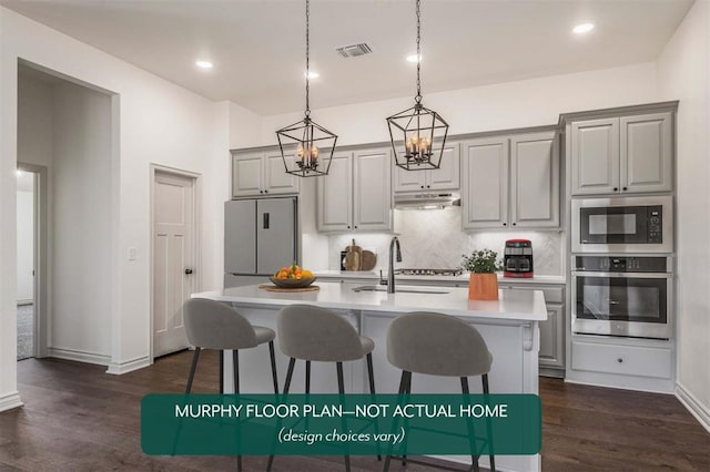 kitchen with gray cabinetry, a center island with sink, stainless steel appliances, and dark hardwood / wood-style floors