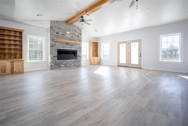 unfurnished living room featuring vaulted ceiling with beams, plenty of natural light, light hardwood / wood-style floors, and a fireplace