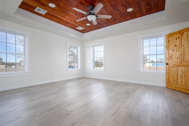 unfurnished room with ceiling fan, light hardwood / wood-style floors, a wealth of natural light, and a tray ceiling