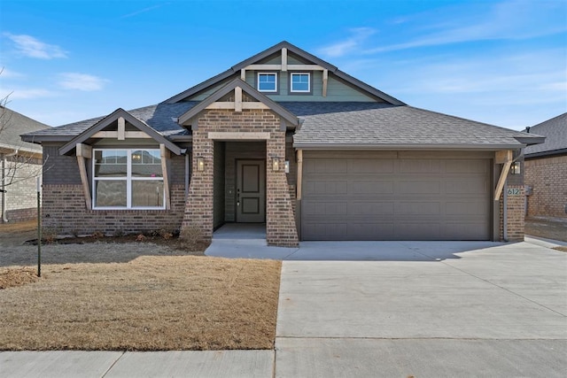 craftsman house featuring driveway, roof with shingles, an attached garage, and brick siding