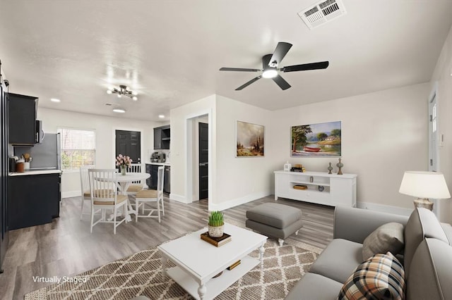 living room featuring ceiling fan and dark hardwood / wood-style floors