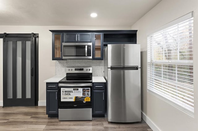 kitchen featuring decorative backsplash, wood-type flooring, and appliances with stainless steel finishes