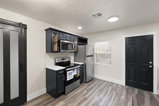 kitchen featuring stainless steel appliances, tasteful backsplash, and light hardwood / wood-style floors