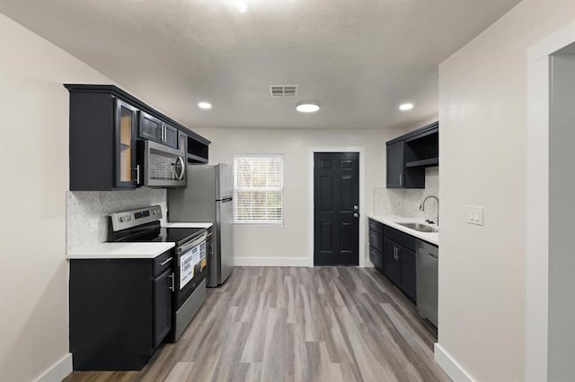 kitchen with wood-type flooring, stainless steel appliances, tasteful backsplash, and sink