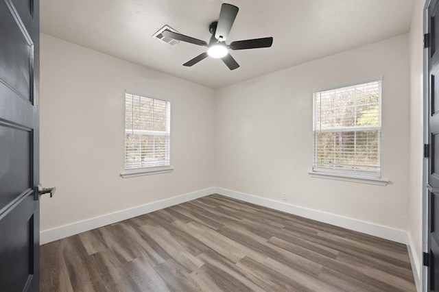 spare room with hardwood / wood-style floors, ceiling fan, and a wealth of natural light