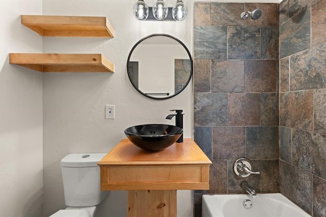 full bathroom featuring sink, tiled shower / bath combo, and toilet