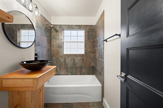 bathroom featuring vanity and tiled shower / bath