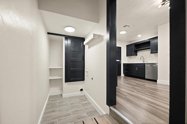 laundry area featuring light hardwood / wood-style floors and sink