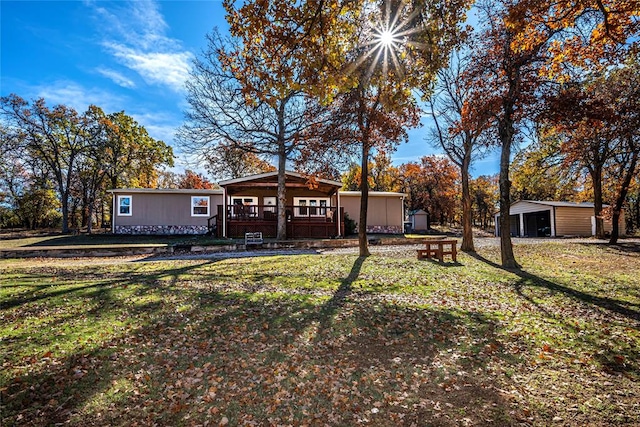 back of house featuring a deck, a storage unit, and a lawn